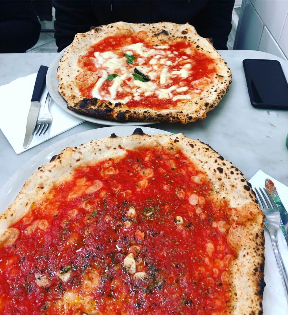 na zdjęciu dwie pizze: marinara, czyli z samym sosem pomidorowym oraz margarita z mozzarellą
